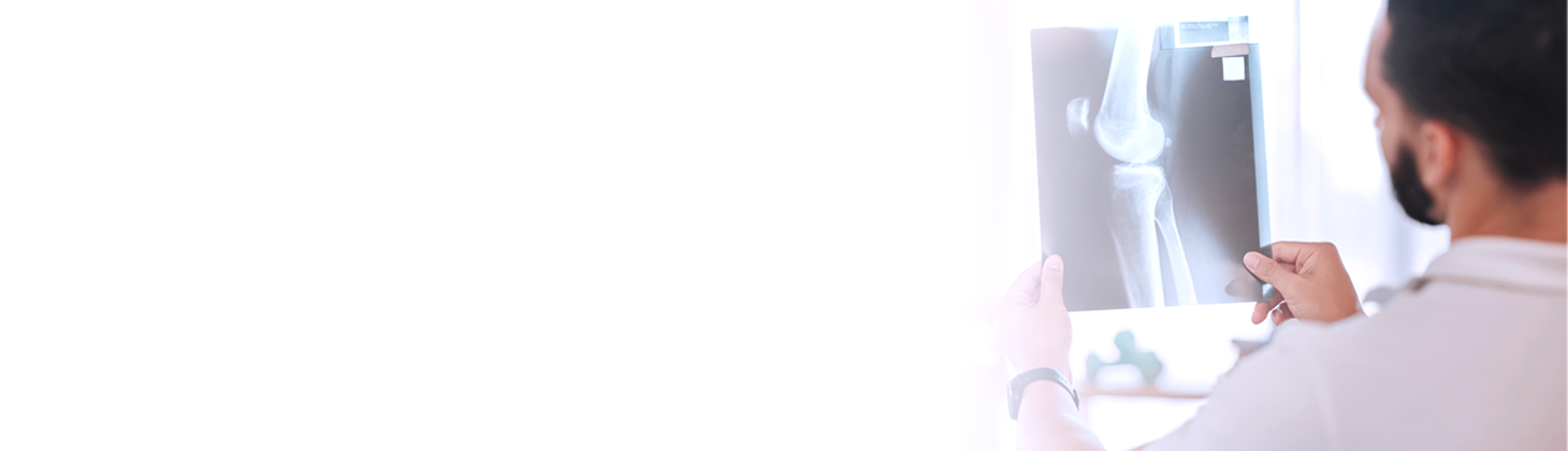 A chiropractor examining a physical X-ray