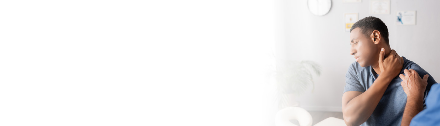 A man holds his neck in a chiropractic office setting.