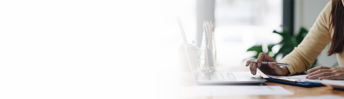 A woman's hand touching the keyboard of her laptop computer.
