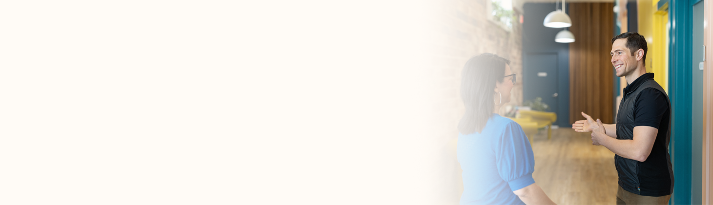 A DC chats with a patient in the hallway of a practice.