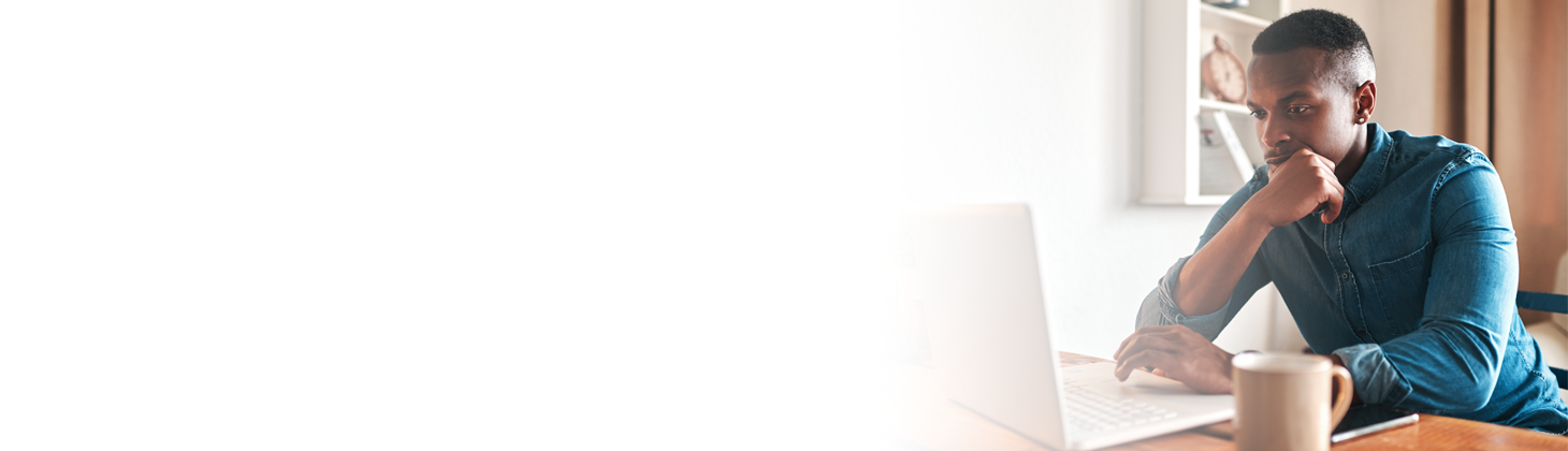 A female chiropractor holds her head while looking at a computer.