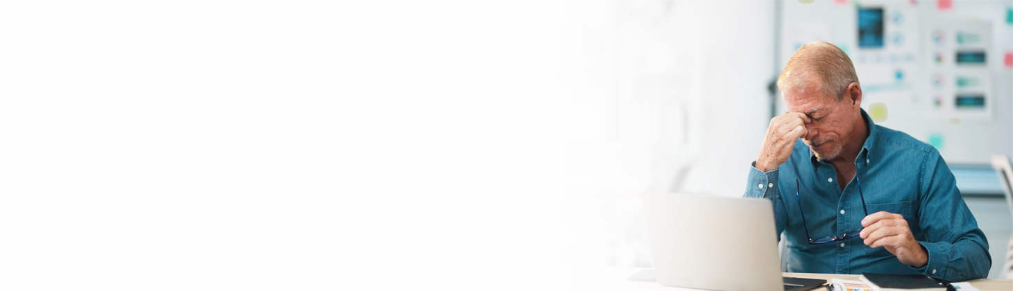 A DC sits at his computer and pinches the bridge of his nose.