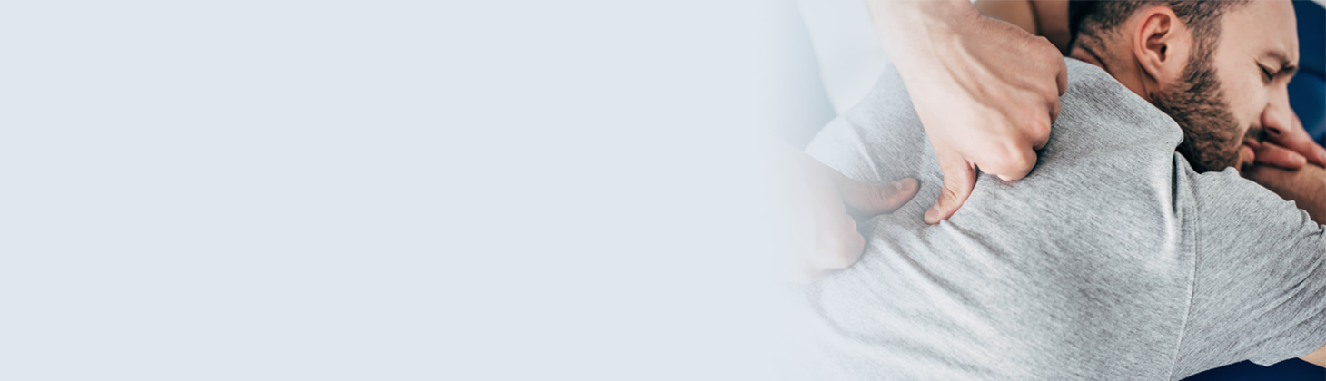 Thumb and fingers manipulating a man's back