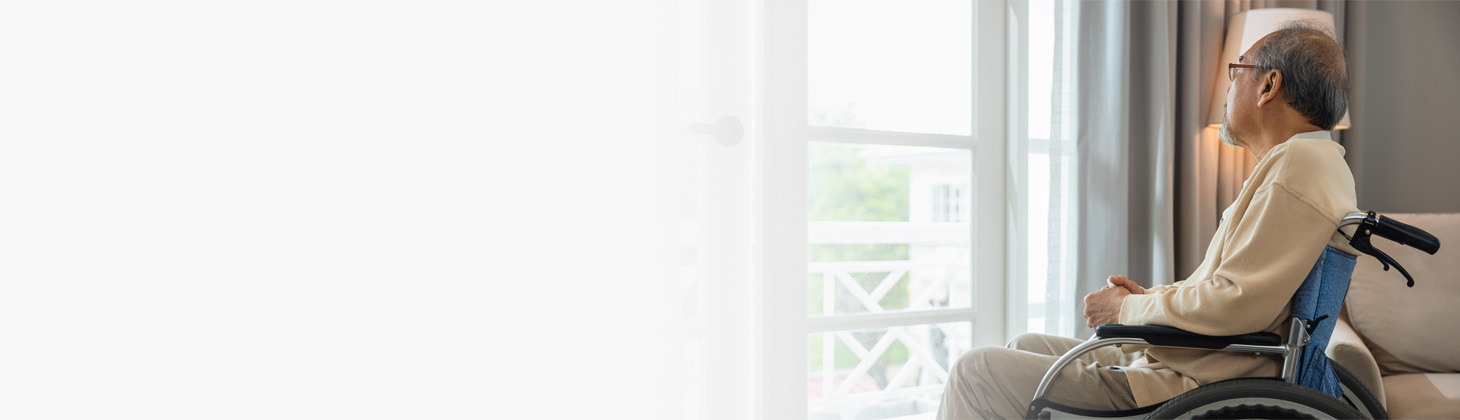 A man in a wheelchair looks out the window