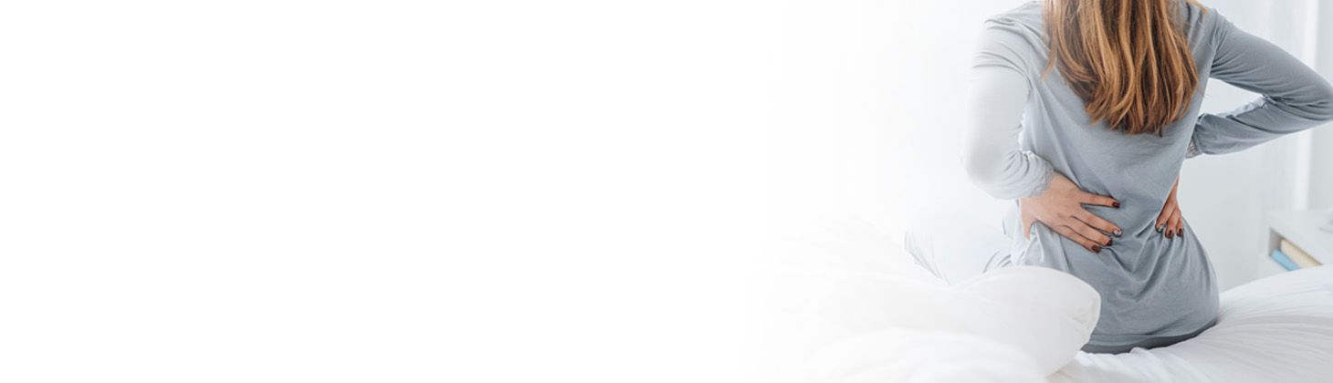 A woman clutches her lower back.