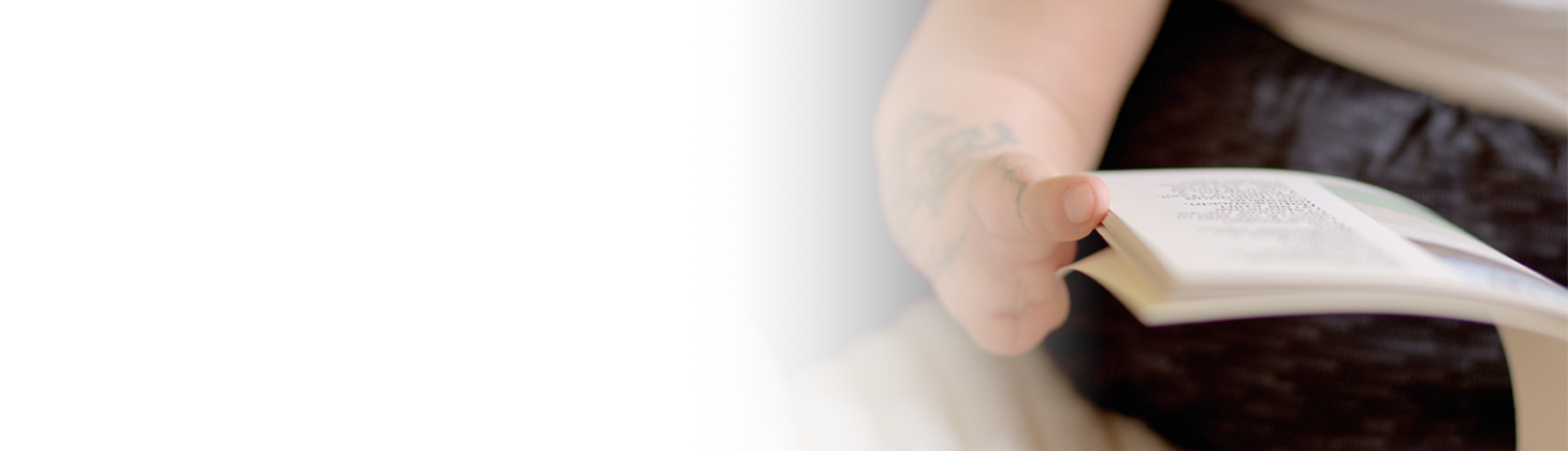 A person with several fingers amputated holds a book.