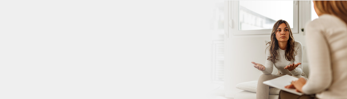 A female patient gestures with her hands and appears to be frustrated.