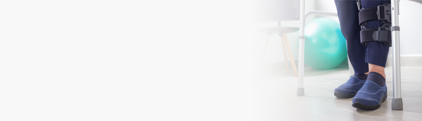 A man works on a laptop with crutches in the foreground from a long term disability injury.