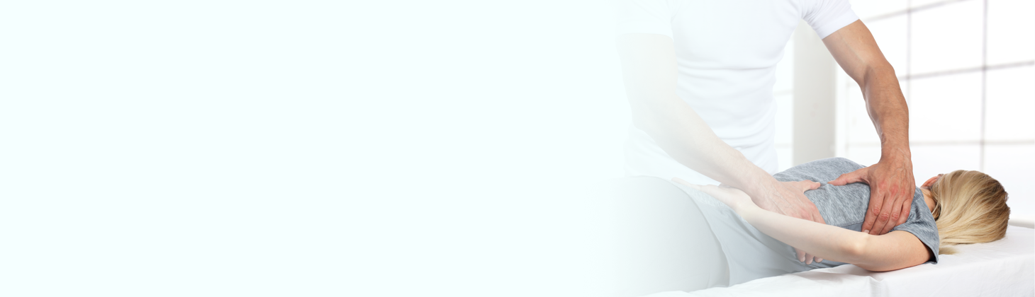 A chiropractor adjusts a woman in a gray shirt